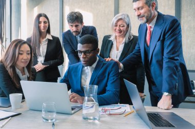 İş adamları, dizüstü bilgisayarlar ve takım çalışması, işbirliği veya ofiste bir pazarlama projesi planlamak için buluşmalar. Profesyonel takım ya da reklam ajansı bilgisayarda, çevrimiçi sunumda ya da grup video çağrısında