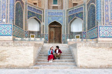 Buhara, Özbekistan Mir-i-Arap Madrasa Kalyan minaresi ve kulesinde oturan genç çift. Camiye çeviri: 