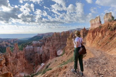 Tatil gezisinde dinlenen bir kız. Thor 'un çekiç büyüsünün yanında duran kadın dağın tepesinde güzel manzaraya bakıyor. Bryce Canyon Ulusal Parkı, Utah, ABD