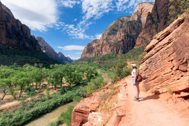 Uçurumun kenarında duran kadının, Utah, ABD 'deki Zion Ulusal Parkı Kanyonu' ndan manzaranın keyfini çıkarırken görüntüsü.. 