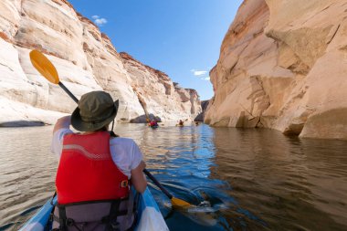 Yaz boyunca Arizona 'da Antilop kanyonunda Powell Gölü' nde kayak, kano ve can yeleğiyle kayak yapan genç ve mutlu bir kız.