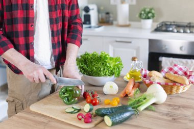 Adam ev mutfağında lezzetli ve sağlıklı bir yemek hazırlıyor.