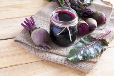 Hafif arka planda sebzeli bir bardak taze pancar suyu.