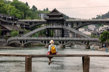 Feng Huang Antik Kasabası 'nın güzel manzarasına bakan genç bayan turist Hunan Eyaleti, Çin' deki ünlü turizm merkezi.