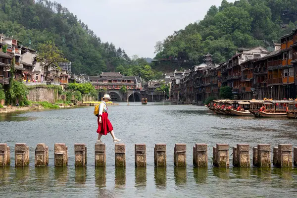 Tarihi Xiangxi Antik Kasabası 'ndaki Tuojiang Nehri' ni ya da Hunan, Çin 'deki Fenghuang Eski Kasabası' ndaki kırmızı elbiseli genç turist..