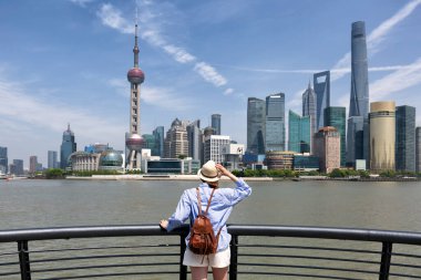Çin, Şangay 'ı ziyaret eden bir kadın gezgin. Sırt çantalı bayan turist Şangay 'da Lujiazui' nin Şangay manzarasına bakıyor. Tatil kavramı