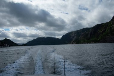 Boat with fish rods and gear with scenic mountains  fjords in the background, Norway 