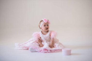 Beyaz arka planda elbise giymiş küçük bir kız.