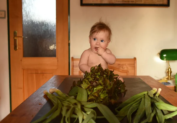 家にレタスがたくさんある赤ん坊の女の子 — ストック写真