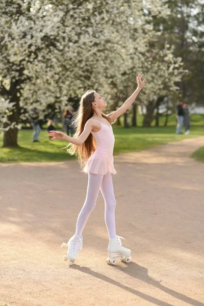春天公园里溜冰鞋上的女孩的肖像 开花的树 — 图库照片