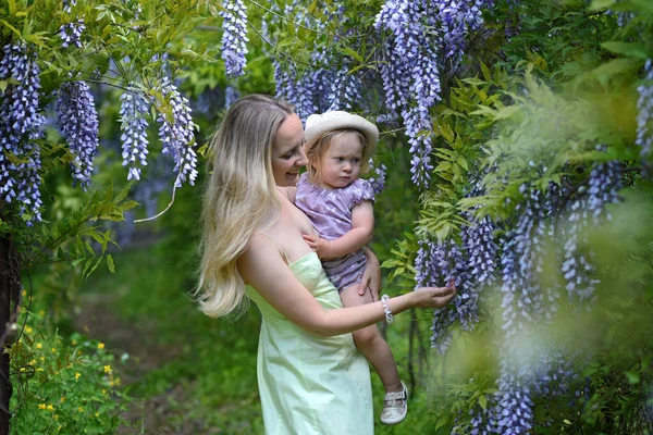 Vrouw Haar Dochtertje Poseren Het Voorjaar Park Met Wisteria Bloemen — Stockfoto
