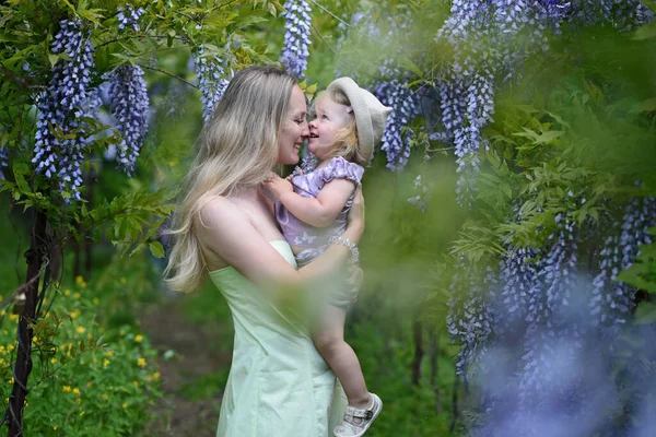 Kislánya Pózol Tavaszi Parkban Lila Virágokkal — Stock Fotó