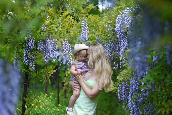 Vrouw Haar Dochtertje Poseren Het Voorjaar Park Met Wisteria Bloemen — Stockfoto