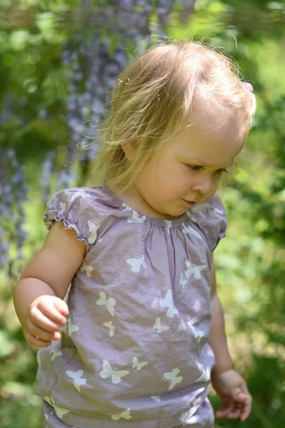 Kislány Lila Virágokkal Spring Parkban — Stock Fotó