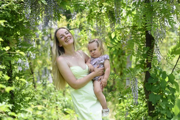 Kislánya Pózol Tavaszi Parkban Lila Virágokkal — Stock Fotó