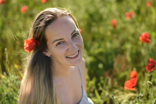 stock image happy woman in a poppy flower field on summer sunny day. 