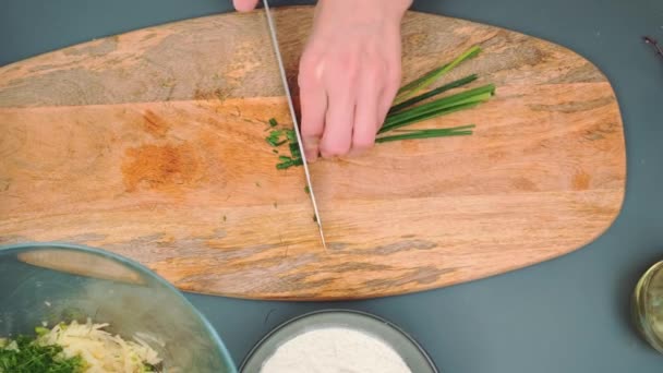 女厨师在厨房桌上的切菜板上切青葱 厨房桌子的顶视图 厨房里的烹调 — 图库视频影像