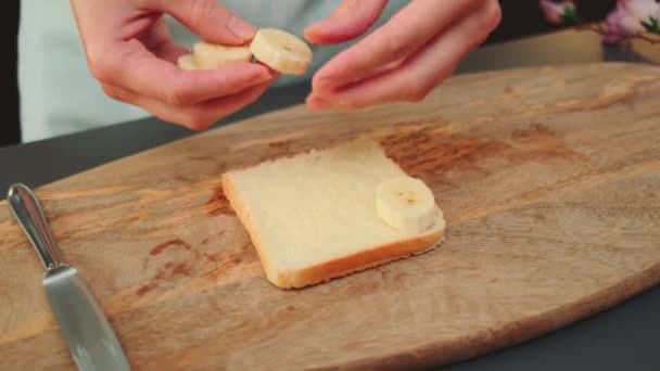 Mãos Mulheres Põem Bananas Fatiadas Pão Torrado Com Manteiga Fechar — Vídeo de Stock