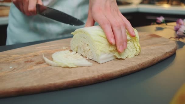 女人的手在切菜板上切大白菜 烹调自制食品的过程 桌子的侧视图 厨房里的烹调 — 图库视频影像