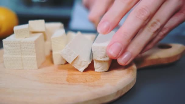 여자는 샐러드 조각으로 치즈를 자릅니다 테이블의 클로즈업 부엌에서 — 비디오
