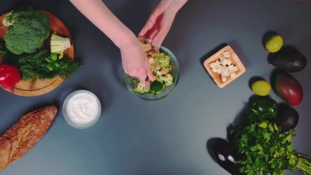 Uma Mulher Adiciona Tofu Picado Uma Salada Brócolis Pepino Vista — Vídeo de Stock