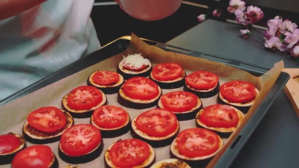 妇女在烤之前用茄子把烤奶酪涂在西红柿上 一张桌子的特写 厨房里的烹调 — 图库视频影像