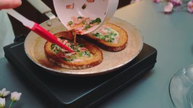 Kızarmış tostun içine yumurta dolduran kadın. Masaya yakın çekim. Mutfakta yemek pişirmek.