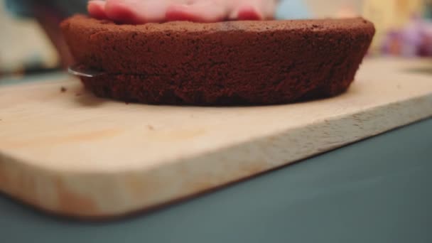 Vrouwelijke Handen Snijden Chocolade Biscuit Cake Twee Delen Een Snijplank — Stockvideo