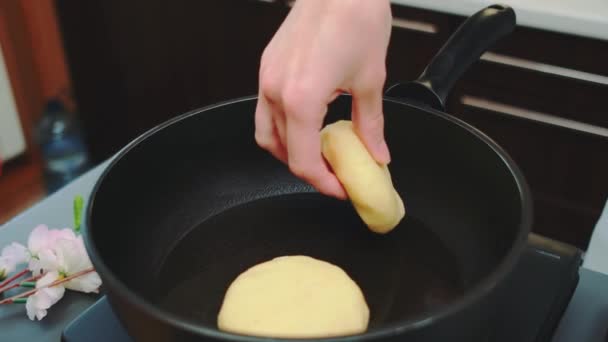 女性的手把土豆面团和填充物放在一个加热的油锅里 厨房桌子中间的镜头 厨房里的烹调 — 图库视频影像
