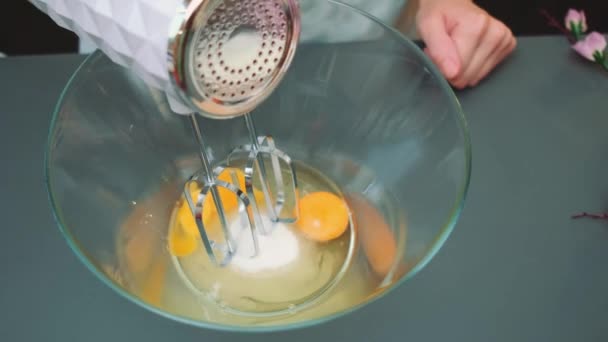 요리사 믹서와 그릇에 익지않는 계란을 테이블의 부엌에서 — 비디오