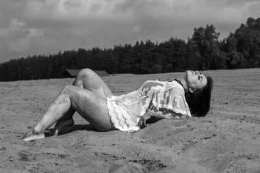 Kumsalda güzel, seksi bir kadın. Siyah beyaz fotoğraflar..