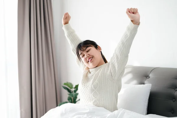 stock image Happy Woman stretching her arms on the bed in the morning.