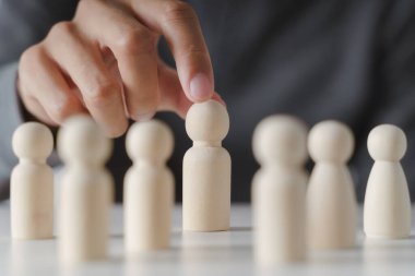 Erkek eli tahta tahta bebek seçer. Liderlik ve iş takımı yaratıcı düşünme ve takım çalışması veya takım oyuncusu konsepti için insan kaynakları.