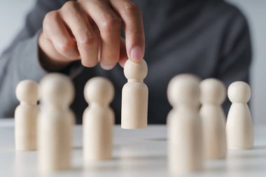 Erkek eli tahta tahta bebek seçer. Liderlik ve iş takımı yaratıcı düşünme ve takım çalışması veya takım oyuncusu konsepti için insan kaynakları.
