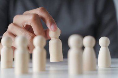 Erkek eli tahta tahta bebek seçer. Liderlik ve iş takımı yaratıcı düşünme ve takım çalışması veya takım oyuncusu konsepti için insan kaynakları.