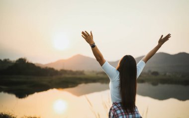 Kollarını açıp dağları izleyen mutlu bir kadın. Seyahat yaşam tarzı başarı konsepti macera aktif tatil açık hava özgürlük duyguları.