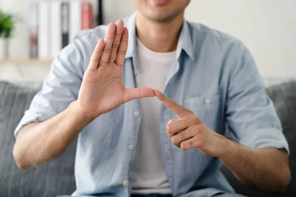 Happy young deaf man using sign Language to communicate with other people