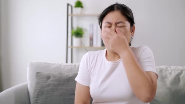 若い女性は 自宅のソファーに座って鼻アレルギーをこすりました インフルエンザ インフルエンザ 医療コンセプト — ストック動画
