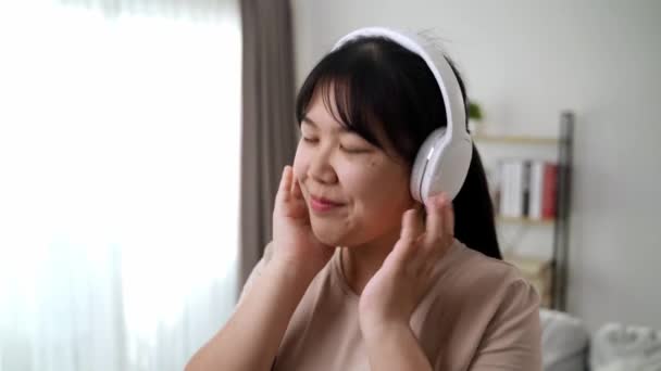 Wanita Muda Mendengarkan Musik Dengan Headphone Dan Santai Sambil Duduk — Stok Video