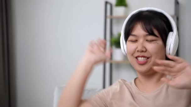 Молода Жінка Слухає Музику Навушниками Танцює Вітальні Вдома — стокове відео