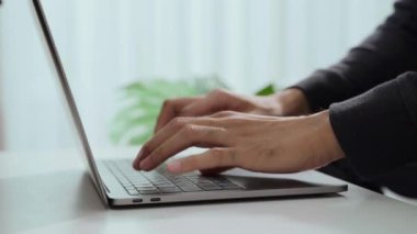 Adamın eli evde ya da ofiste dizüstü bilgisayarda klavye kullanıyor. Çalışıyor, mesajlar gönderiyor, sohbet ediyor, internette geziniyor ve sosyal ağları kullanıyor..