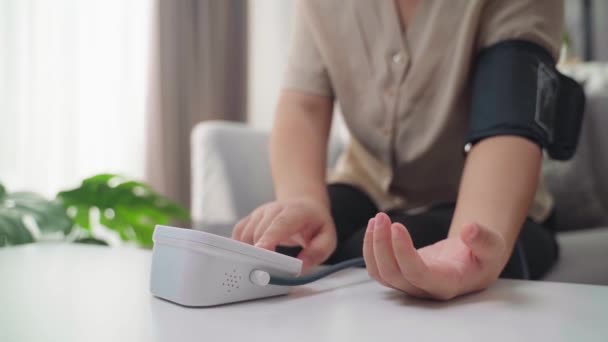 Egyedül Méri Vérnyomását Egy Hordozható Vérnyomásmérővel Ami Otthon Kanapén Egészségügyi — Stock videók