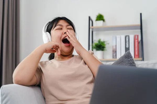 Asyalı kadın çalışırken, çalışırken ya da evdeki oturma odasındaki kanepede film izlerken esniyor..