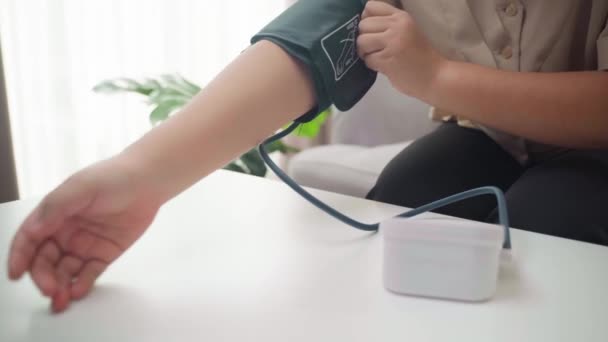 Kobieta Sama Mierzy Ciśnienie Krwi Pomocą Przenośnego Ciśnieniomierza Siedzącego Kanapie — Wideo stockowe
