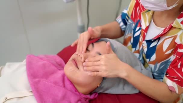 Eine Frau Lässt Sich Von Einer Kosmetikerin Ihr Gesicht Massieren — Stockvideo
