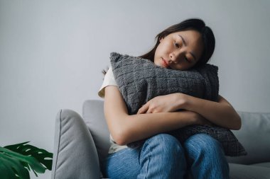 Mutsuz, bunalımlı kadın kanepede oturuyor. Üzgün ve yorgun görünüyor..