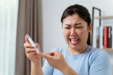 Kan şekeri seviyesini Glikoz ölçer, Sağlık ve Sağlık, Diyabet, glisemi konseptine göre ölçmek için parmak üzerine mızrak kullanan Asyalı kadın.