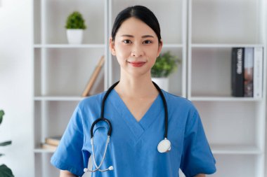 Asyalı kadın doktor ya da hemşire, ofisinde steteskop asılı duruyor. Sağlık işçisi, Tıp Profesyoneli..