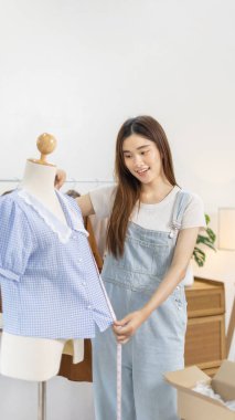 Professional female designers use a tape measure around the shirt in the studio, Fashion designer, Creativity and ideas, Mannequin, Shirt sketch, Color scheme, Garment accessories.