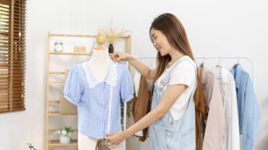 Professional female designers use a tape measure around the shirt in the studio, Fashion designer, Creativity and ideas, Mannequin, Shirt sketch, Color scheme, Garment accessories.